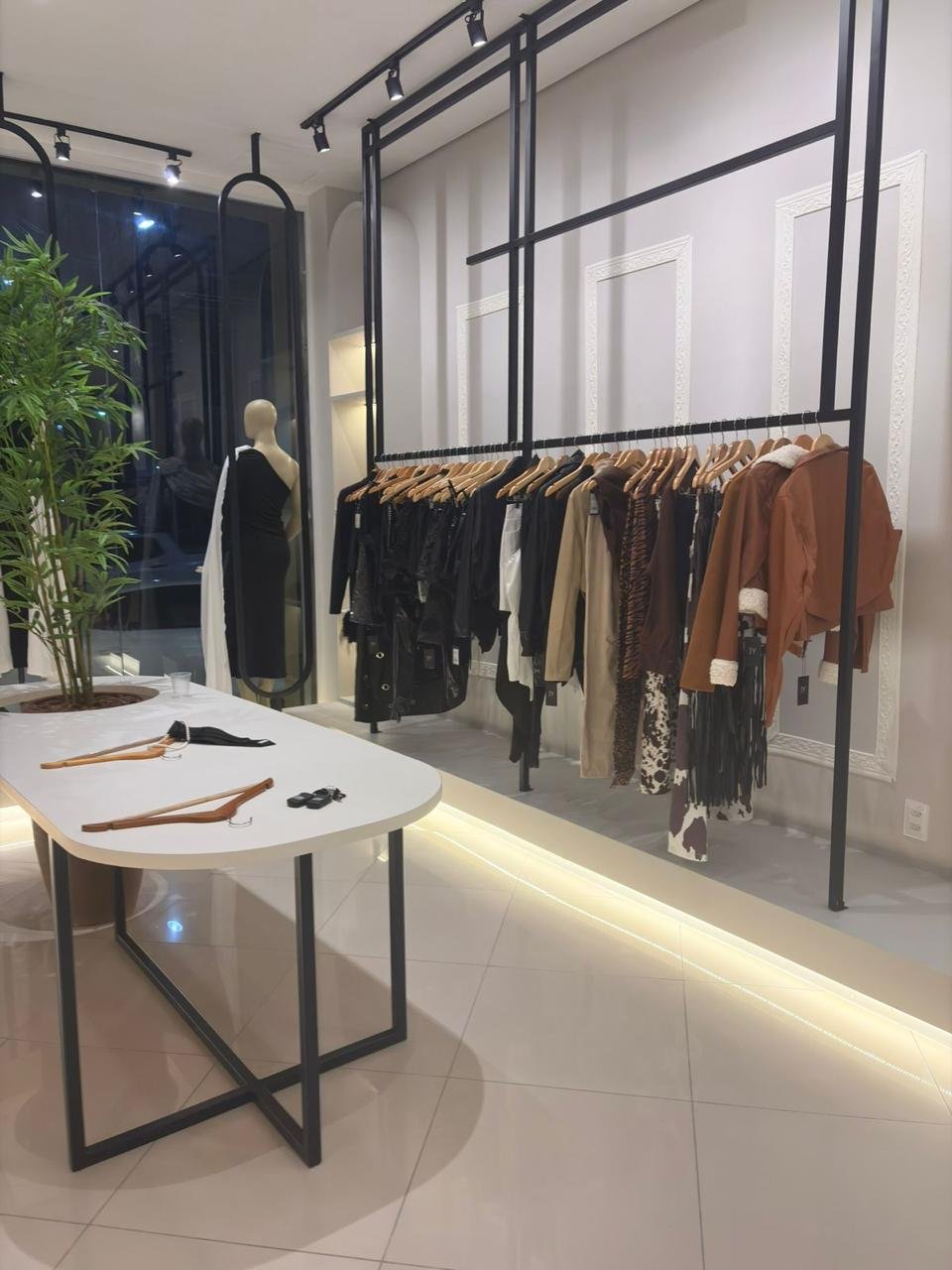 Arara de roupas com iluminação linear e mobiliário sob medida